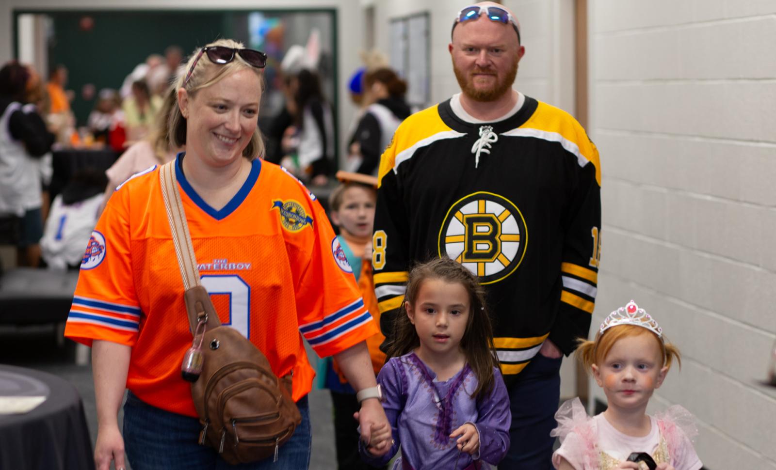 A hallway full of families dressed in costumes visit Trick or Treat at the Trail