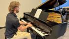 Sean Stone plays the piano in DeMent Auditorium at Lincoln Trail College.