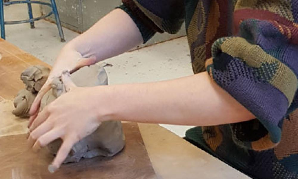 Hands molding clay