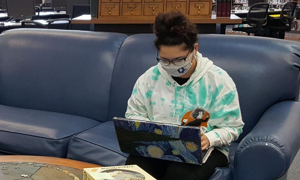 Student using a laptop in the library