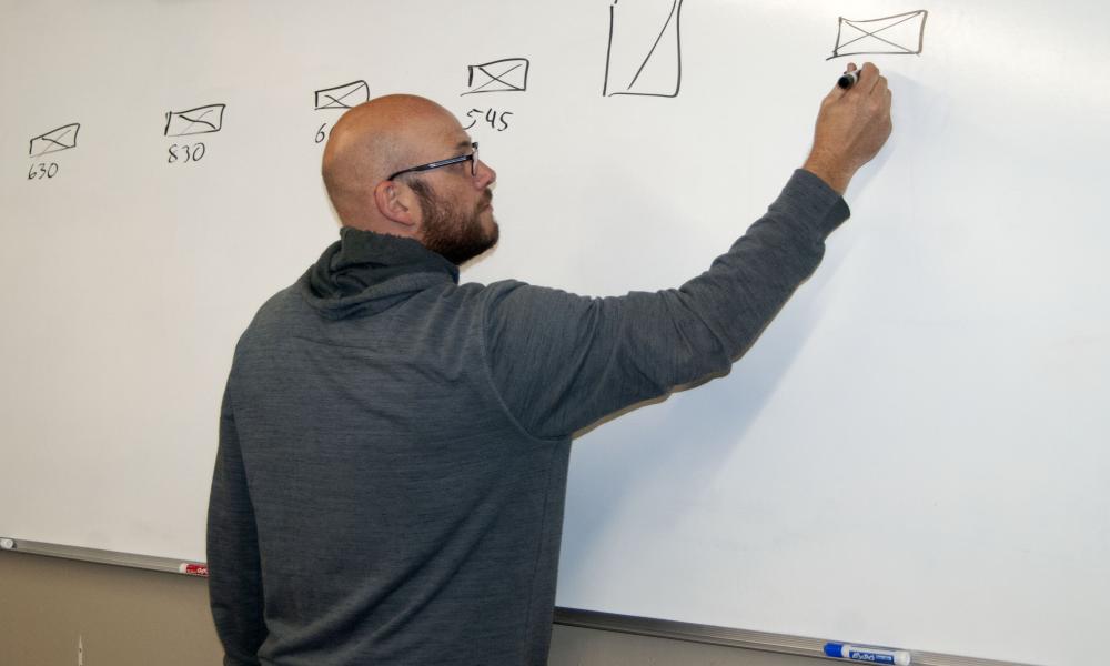 Logan Marshall writing on a whiteboard