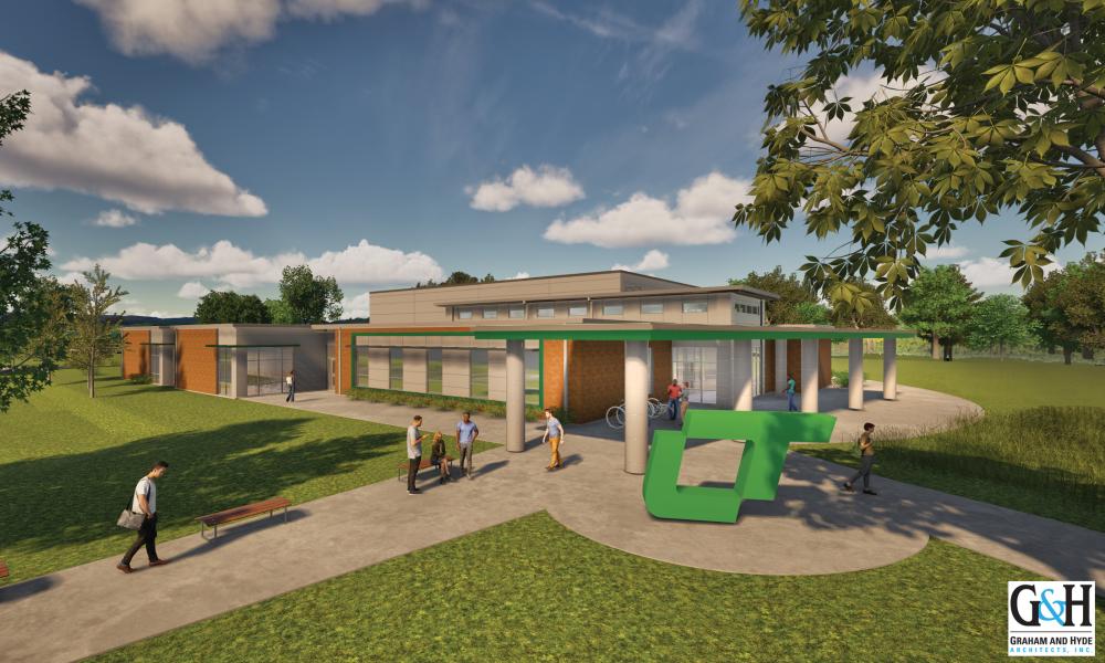 Architectural rendering of the future Lincoln Trail College Technology Center. The modern, single-story building features a mix of red brick and light-colored paneling, with large windows and a green-accented entrance canopy supported by columns. Students are depicted walking and talking along paved paths and sitting on benches in a landscaped area. A large green sculpture resembling the letters “LT” stands near the entrance.