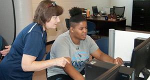 Instructor working with student at a computer